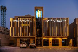 two buildings with cars parked in a parking lot at Royal Palace Hotel - Almoroj in Riyadh