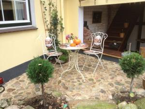 a patio with two chairs and a table with pumpkins at Landhaus Tewel Hotel mit Restaurant 14KM vom Heide-Park in Tewel
