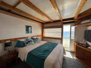 ein Schlafzimmer mit einem großen Bett und einem großen Fenster in der Unterkunft Ritrella Floating Hotel in Male City