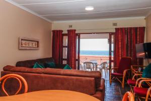 a living room with a couch and a view of the ocean at Natspat 14 in Margate +14 photos