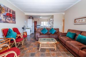 a living room with a brown leather couch and chairs at Natspat 14 in Margate