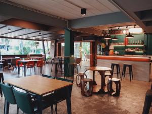 a restaurant with tables and chairs and a bar at Hotela Boutique Resort in Suphan Buri