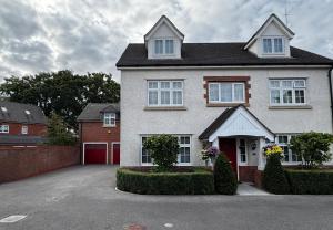 a large white house with a red garage at Guest Room by Amanda & David in Devizes Wiltshire in Bishops Cannings