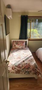 ゴールドコーストにあるHomestay on the hill 3のベッドルーム1室(花柄の掛け布団、窓付) +5枚の写真