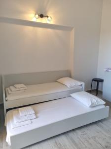 a white room with two beds and a light at Sunset Apartments & Studios in Limenaria