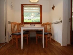 a dining room table with two chairs and a window at Ferienhaus in der Nähe des Sees, Haustierfrei in Clausthal-Zellerfeld +8 photos