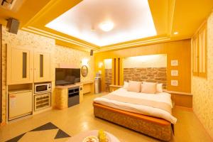 a bedroom with a large bed and a television at HOTEL WiLL 大高 in Nagoya
