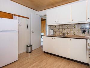 a kitchen with white cabinets and a refrigerator at 6 person holiday home in Toftlund in Toftlund