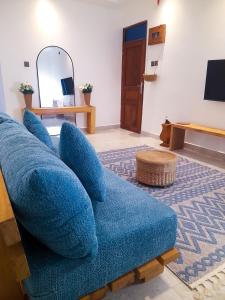 a blue couch in a living room with a mirror at Chui de eagle in Mombasa