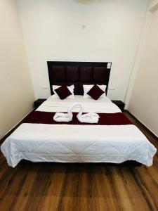 Un dormitorio con una cama grande con dos toallas encima. en HL Residency Near Expo Mart Centre, en Greater Noida