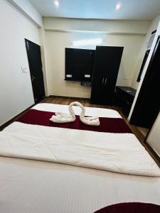 Un dormitorio con una cama con dos zapatos blancos. en HL Residency Near Expo Mart Centre, en Greater Noida 4 fotos más