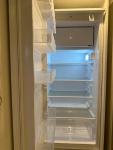 Un refrigerador vacío con la puerta abierta en una habitación. en New, modern and bright studio, en Neuilly-sur-Seine