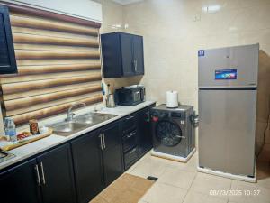 a kitchen with a refrigerator and a washing machine at EVANNA SUITE & HOTELs VIP ايفانا للشقق الفندقيه VIP in Amman