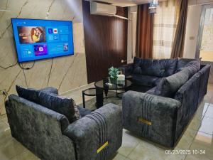 a living room with two couches and a flat screen tv at EVANNA SUITE & HOTELs VIP ايفانا للشقق الفندقيه VIP in Amman