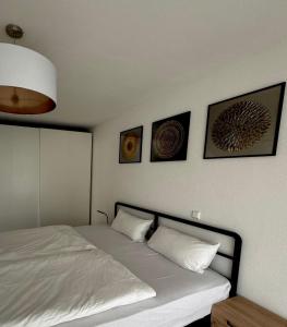 a bedroom with a bed with four pictures on the wall at AIL Kün Studio in Künzelsau +5 photos