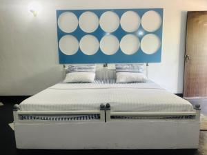 a large bed with a blue and white headboard at Rock Hill Hotel in Galle