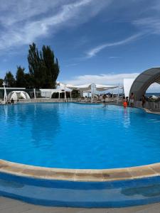a large blue swimming pool with a blue sky at Villa Caprice 42 Issyk Kul in Bosteri