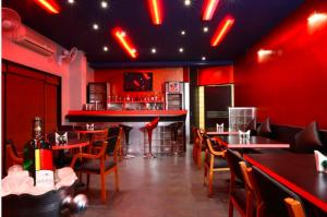 a restaurant with red walls and tables and chairs at Hotel Orient Crown, Kolhapur in Kolhapur