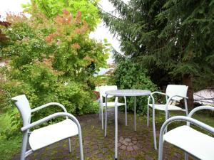 a group of white chairs and a table in a garden at Apartment in Tschagguns near Ski Slopes in Tschagguns