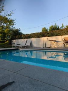 a swimming pool with two lawn chairs at Vakantiewoning De Woestijn - Den Ast in Roosdaal