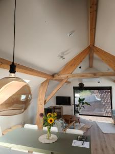 a living room with a table with a vase of flowers at Vakantiewoning De Woestijn - Den Ast in Roosdaal