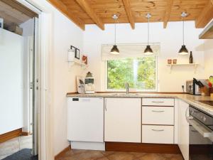 a kitchen with white cabinets and a window at 5 star holiday home in Grenaa in Grenå +16 photos