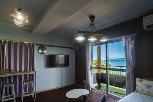 a bedroom with a large window with a view of the ocean at Sion fusaki Beachfront in Ishigaki Island +34 photos