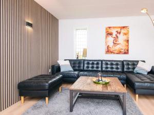 un salon avec un canapé en cuir et une table dans l'établissement Luxury Spa Retreat in Thorsminde - By Traum Ferienwohnungen, à Ulfborg
