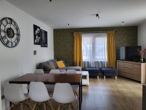 a living room with a couch and a table and chairs at Casa Axente in Baia-Sprie