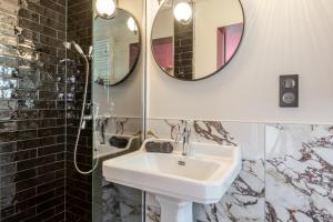 a bathroom with a sink and a mirror at Spa privatif - La Courtisane - Terrasse 40m2 - love-room-alsace-67 in Niederbronn-les-Bains