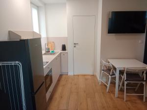 a small kitchen with a table and a refrigerator at Wojska Polskiego 18 in Braniewo +4 photos