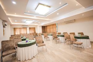 una sala de reuniones con mesas y sillas en una habitación en Hotel Konark - Vijay Nagar, en Indore