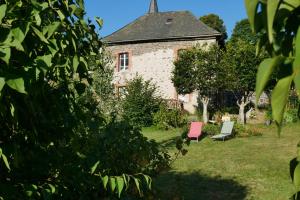 an old building with two chairs in the yard at L'Estive du Claux in Le Claux