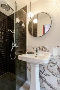 a bathroom with a sink and a mirror at Spa privatif - La Courtisane - Terrasse 40m2 - love-room-alsace-67 in Niederbronn-les-Bains +23 photos
