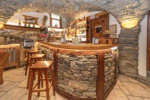 a bar in a restaurant with a stone wall at Chalet Chez Nous in Sauze dʼOulx