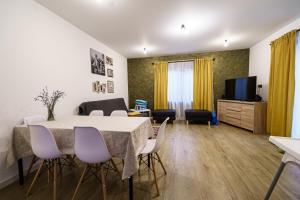 a living room with a table and chairs and a television at Casa Axente in Baia-Sprie +16 photos