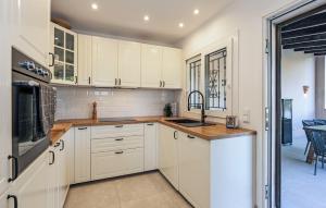 a kitchen with white cabinets and a sink at Casa Soleada in Capdepera