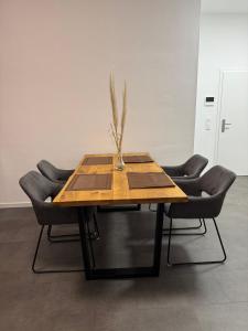 a wooden table with chairs and a vase with a plant on it at Ferienwohnung Alina in Werne an der Lippe