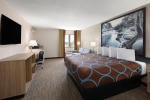 a hotel room with a large bed and a desk at Super 8 by Wyndham Tucson/Grant Road Area AZ in Tucson +19 photos