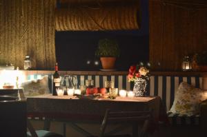 a table with candles and flowers and a bottle of wine at Borda de Fadrín in Ipiés