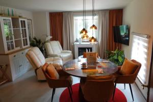 a living room with a table and chairs and a living room at Le Grand Jardin in Dalhem