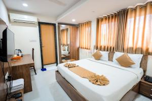 Un dormitorio con una cama grande y un televisor. en Hotel Konark - Vijay Nagar, en Indore