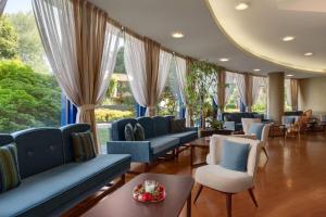 a waiting room with blue couches and chairs at Dolce by Wyndham Milan Malpensa in Somma Lombardo