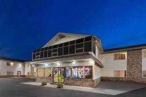 un gran edificio blanco con ventanas por la noche en Baymont by Wyndham Iron Mountain, en Iron Mountain