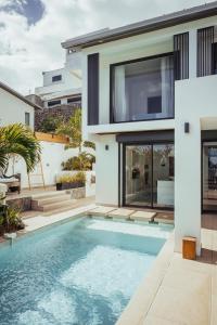 a villa with a swimming pool in front of a house at Villa Sunset St Gilles in Saint-Paul