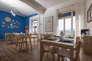 a dining room with blue walls and wooden tables and chairs at Garibaldi R&B in Messina