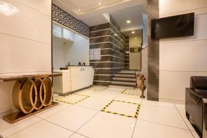 a lobby with a staircase and a tv on a wall at Hotel Laaiba Residency in Mumbai +19 photos