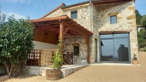 an external view of a stone house with a patio at Gite Du Buisson in Parent