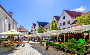 an outdoor market with tables and umbrellas on a street at Bergblick in Weilheim in Oberbayern