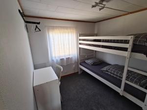 a dorm room with two bunk beds and a desk at Enkelt nära havet in Skummeslövsstrand